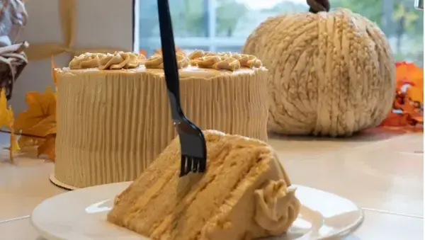 A piece of cake served in a small plate with a fork